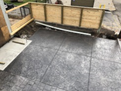 In place of the dilapidated kitchen addition will be this stamped concrete car pad.